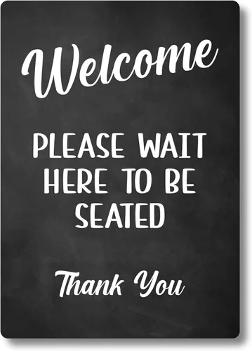 Letrero con texto en inglés "Please Wait Here To Be Seat", disponible como letrero independiente o adhesivo, ideal para cafeterías, restaurantes o